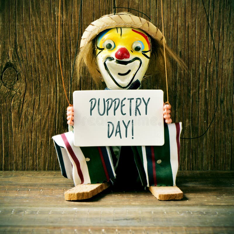 Stara marionetka z signboard z teksta puppetry dniem zdjęcia stock Stara marionetka z signboard z teksta puppetry dniem zdjęcia stock