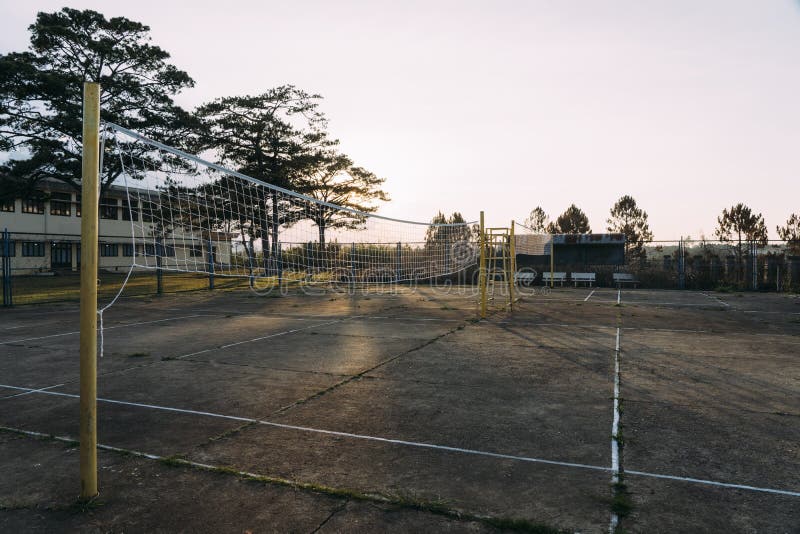 Old beat-up cement volleyball courts with yellow poles during sunset in Dalat, Vietnam. Old beat-up cement volleyball courts with yellow poles during sunset in Dalat, Vietnam