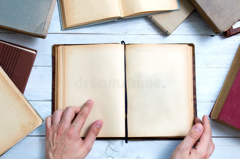 Old books with empty pages for your text and man's hand shows important place. Old books with empty pages for your text and man's hand shows important place.