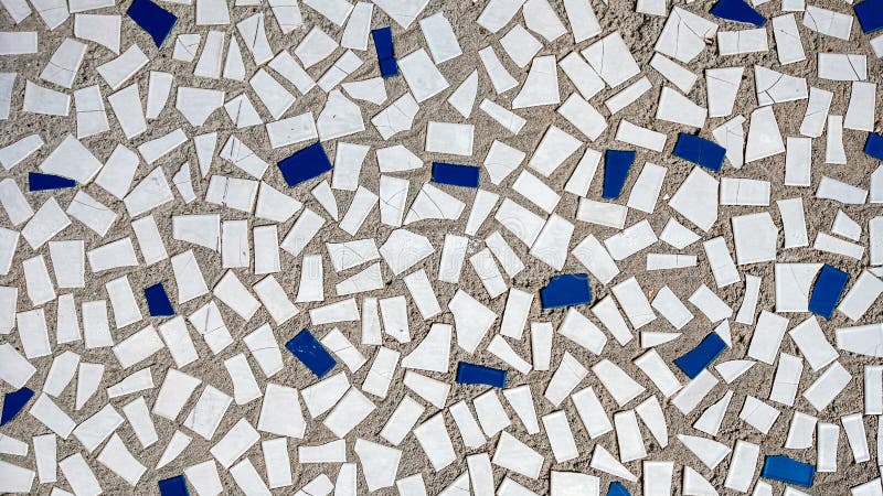 Old tiles in concrete, mosaic, broken ceramics in building. Background of a house city. Old tiles in concrete, mosaic, broken ceramics in building. Background of a house city.