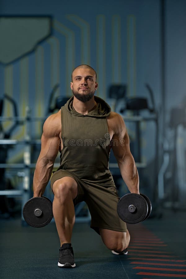 Stark man som gör lungor med proffsbälg i gymmet arkivbilder