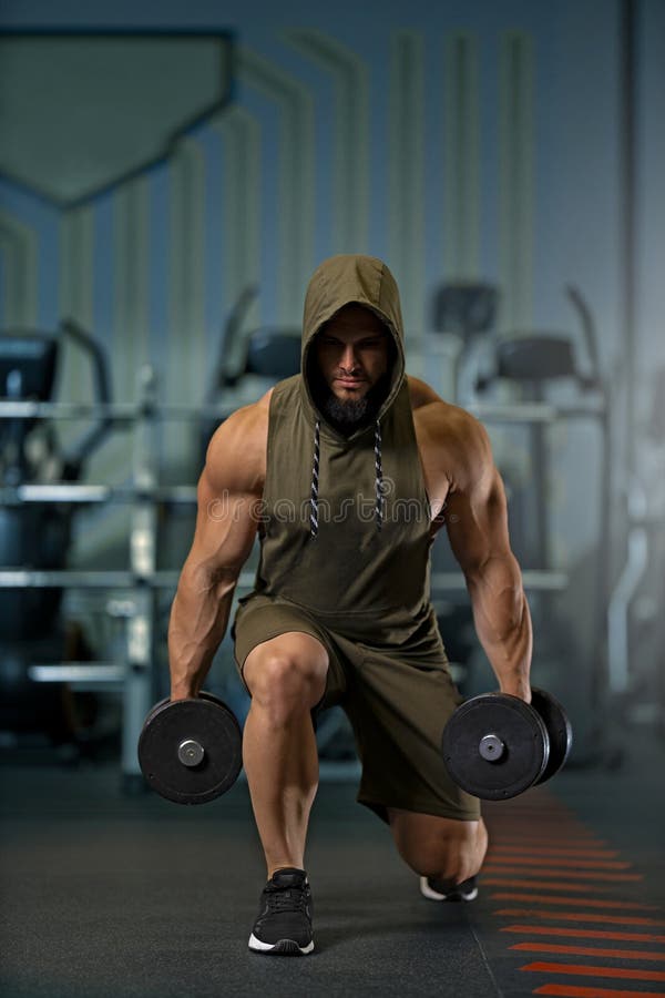 Stark man som gör lungor med proffsbälg i gymmet arkivbild