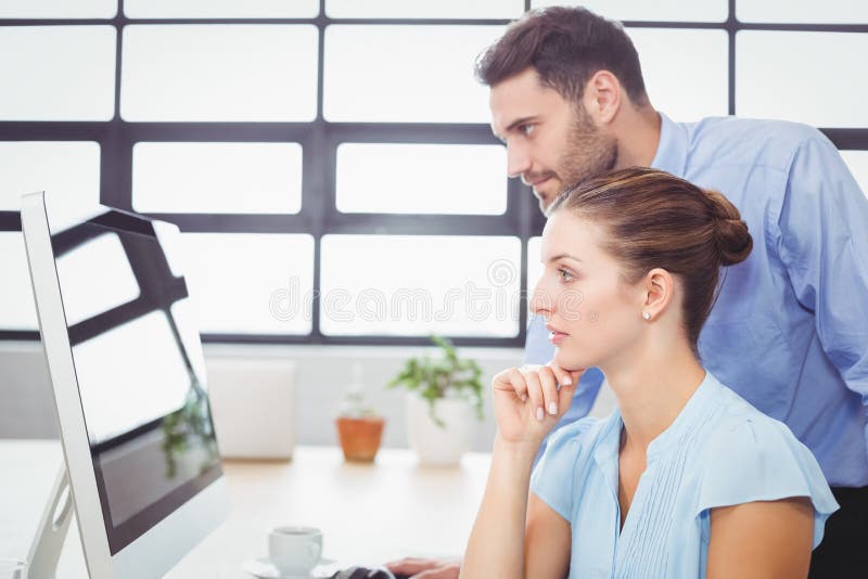 Starke Geschäftsleute, die Computermonitor betrachten stockfotografie Starke Geschäftsleute, die Computermonitor betrachten stockfotografie