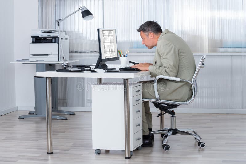 Starker Geschäftsmann-Using Computer At-Schreibtisch stockbild