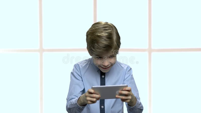 Starker kleiner Junge, der bewegliches Spiel spielt stock video