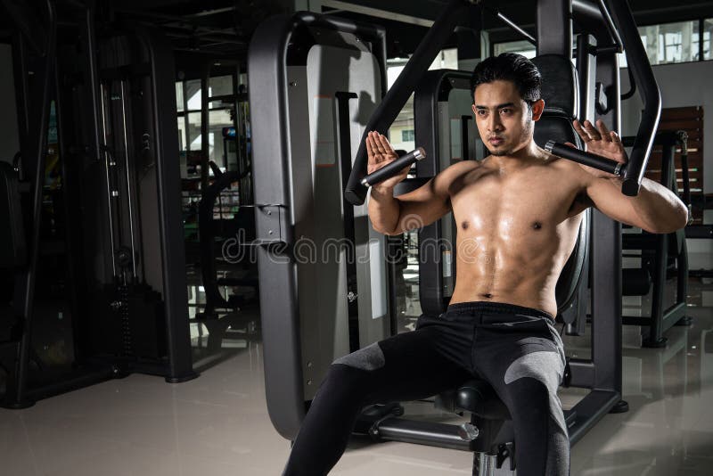 Starker muskulöser Mann, der für Training in crossfit Turnhalle sich vorbereitet Übendes Quersitztraining des jungen Athleten stockbild Starker muskulöser Mann, der für Training in crossfit Turnhalle sich vorbereitet Übendes Quersitztraining des jungen Athleten stockbild
