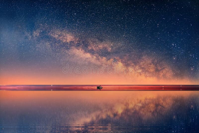 Starry night universe at  sea blue  pink cloudy sky sunset light reflection on water  reflection on horizon boat skyline  nature