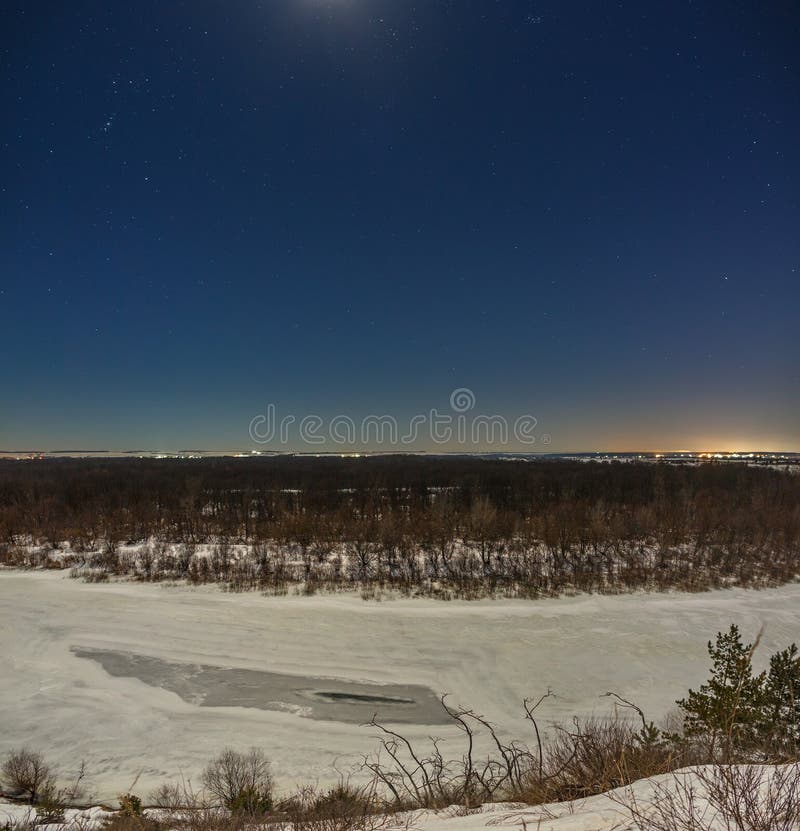 Stars in the night sky. Winter landscape with a frozen river photographed under the full moon stock photo Stars in the night sky. Winter landscape with a frozen river photographed under the full moon stock photo