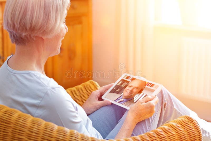 Starsza kobieta, która uczy się za pomocą komputera typu tablet