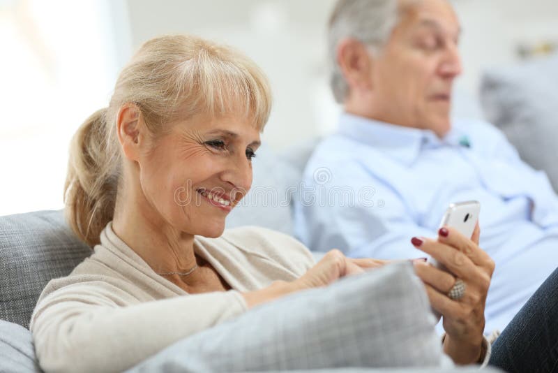 Starsza kobieta używa smartphone w domu obrazy stock Starsza kobieta używa smartphone w domu obrazy stock