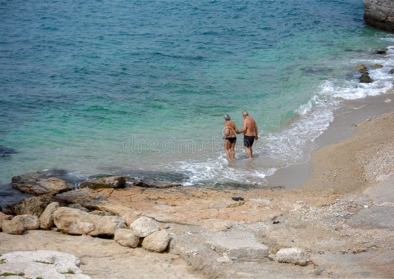 Starsze osoby dobierają się iść dla pływać przy małą plażą w Piraeus mieście Grecja fotografia stock Starsze osoby dobierają się iść dla pływać przy małą plażą w Piraeus mieście Grecja fotografia stock