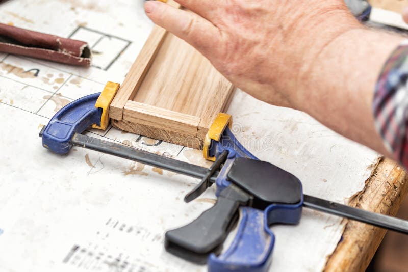 Starszy cieśla klei drewnianą rzemiosło powierzchnię i łączy z kahatami Woodwork cieśla z wyposażeniem i narzędziami przy warszta zdjęcia royalty free Starszy cieśla klei drewnianą rzemiosło powierzchnię i łączy z kahatami Woodwork cieśla z wyposażeniem i narzędziami przy warszta zdjęcia royalty free