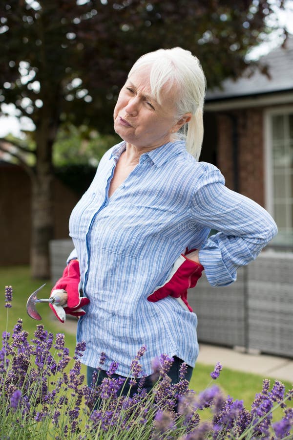 Starszy kobiety cierpienie Od Backache Podczas gdy Uprawiający ogródek W Domu
