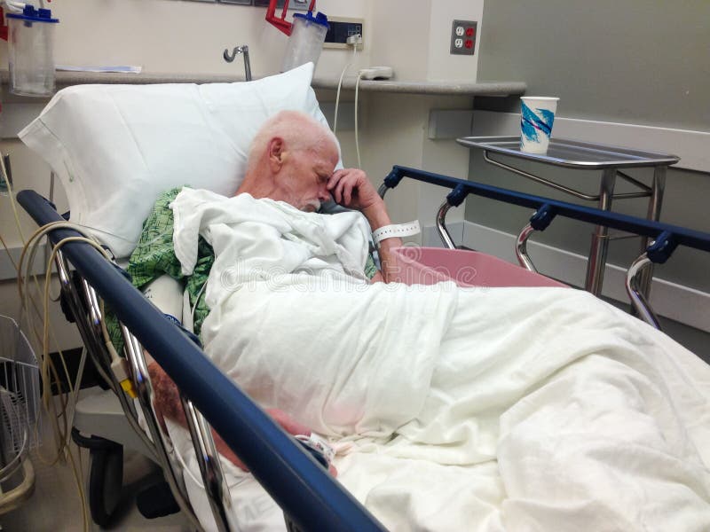 Starszy męski pacjent szpitala w łóżku szpitalnym