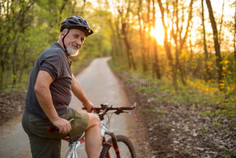 Starszy mężczyzna na jego rowerze górskim outdoors obraz stock Starszy mężczyzna na jego rowerze górskim outdoors obraz stock
