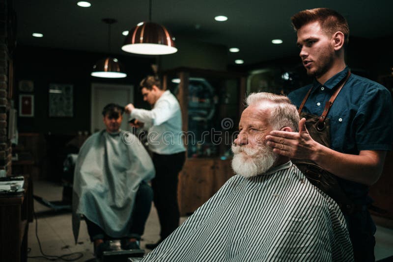 Starszy mężczyzna odwiedza hairstylist w fryzjera męskiego sklepie zdjęcia stock Starszy mężczyzna odwiedza hairstylist w fryzjera męskiego sklepie zdjęcia stock