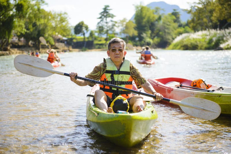 Starszy mężczyzna paddling kajaka zdjęcie stock Starszy mężczyzna paddling kajaka zdjęcie stock