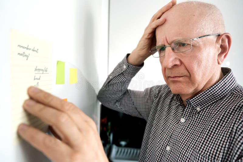 Starszy mężczyzna z demencją, patrzeje notatki