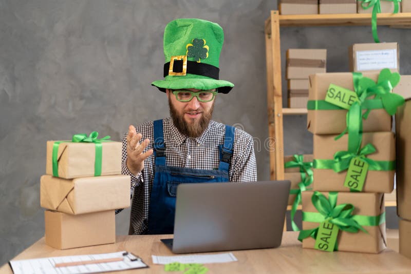 Starta säljaren för småföretag som säljer leprechaun förbereda paketlåda för leverans till kund med hjälp av dator. online royaltyfria bilder