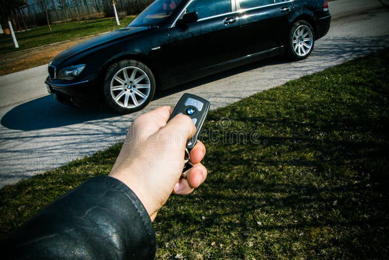 Starttangent av BMW 750 i en manlig hand arkivbild Starttangent av BMW 750 i en manlig hand arkivbild