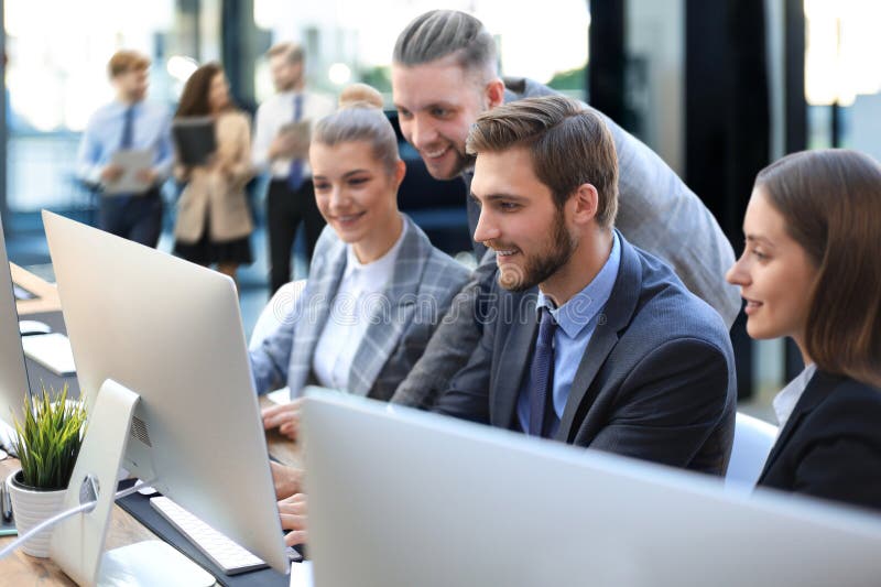 Startup business team on meeting in modern bright office interior brainstorming, working on tablet and PC computers. stock photo