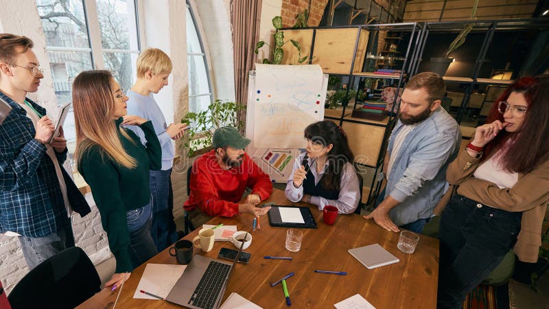 Startup coworkers analyzing strategy around conference table. royalty free stock images
