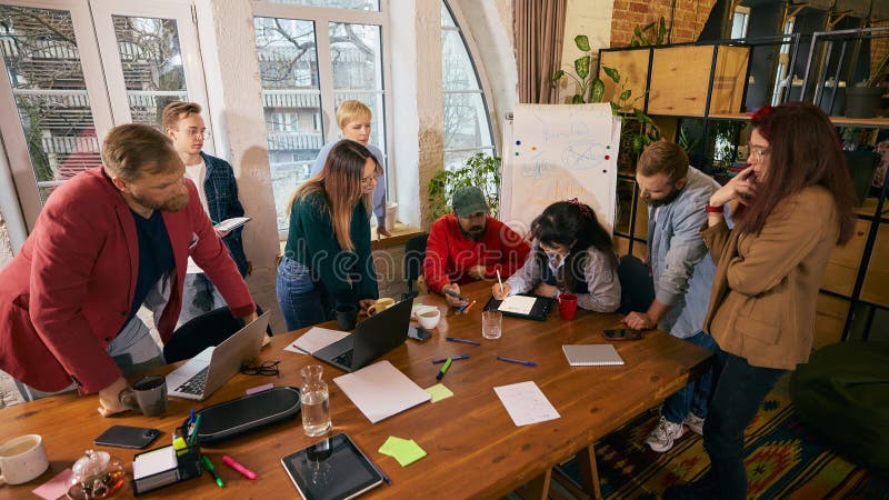Startup team brainstorming around table in modern office. stock photography