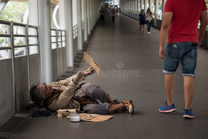 Stary bezdomny mężczyzna błaga dla pieniądze