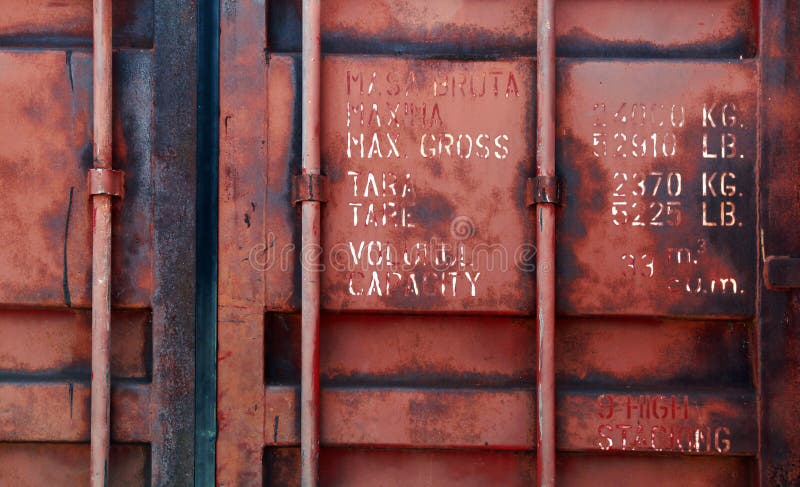 Old red shipping container door with technical characteristics text, background photo texture. Old red shipping container door with technical characteristics text, background photo texture