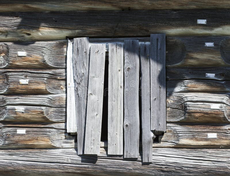 Old window hammered wooden planks of a wooden house, an abandoned farmhouse Russia. Disruption in the village, the abandoned settlements. Old window hammered wooden planks of a wooden house, an abandoned farmhouse Russia. Disruption in the village, the abandoned settlements