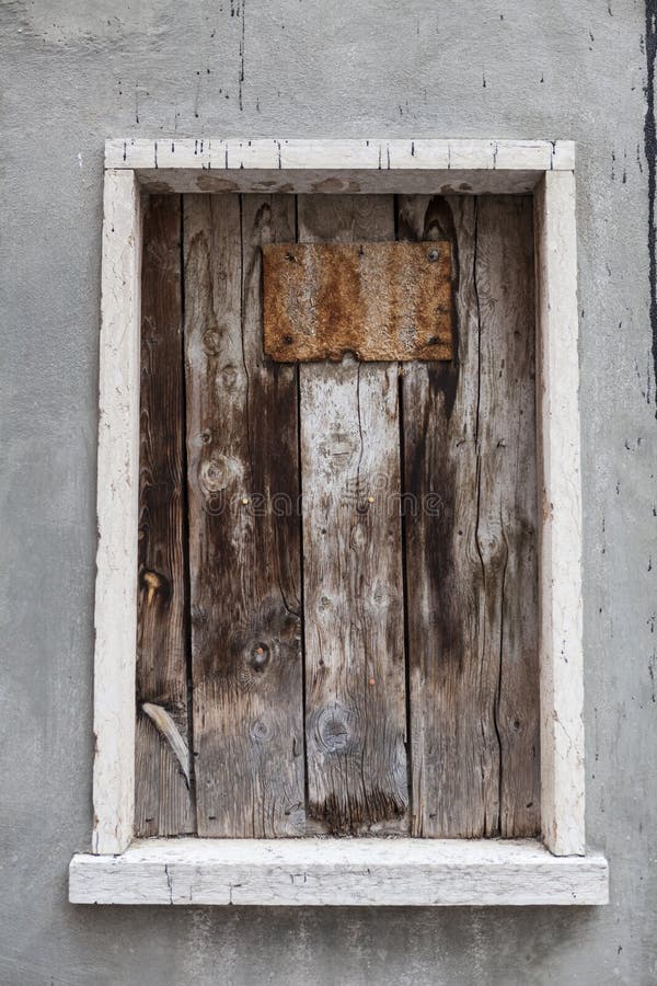 Old window hammered wooden planks on a stone wall, an abandoned farmhouse Provence. France. Old window hammered wooden planks on a stone wall, an abandoned farmhouse Provence. France