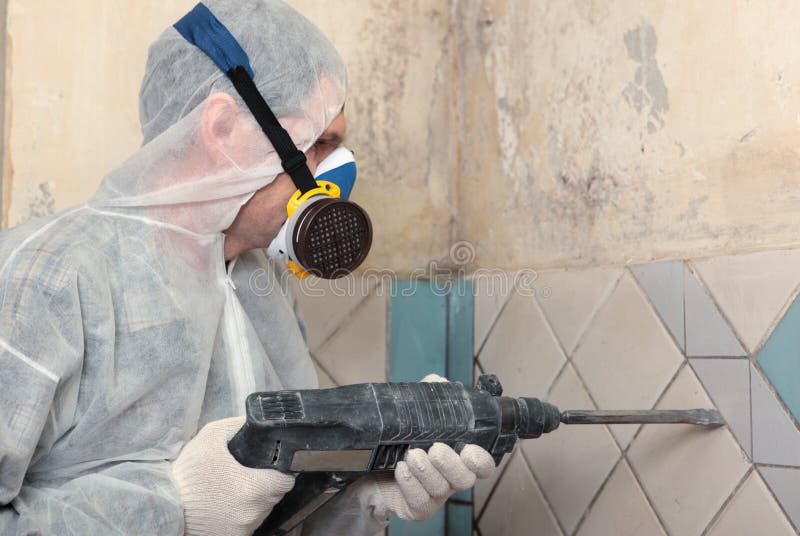 Contractor removing old tiles from the wall. Contractor removing old tiles from the wall