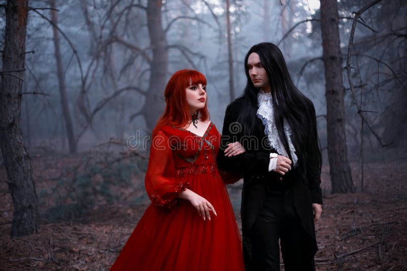 Stary styl filmowy z dodanym ziarnem kina. romantyczna gotycka para w ruchu chodząca w głębokim lesie ciemne drzewo. miłość gotyck