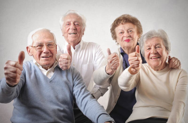 Two old men and two women with their thumbs up. Two old men and two women with their thumbs up