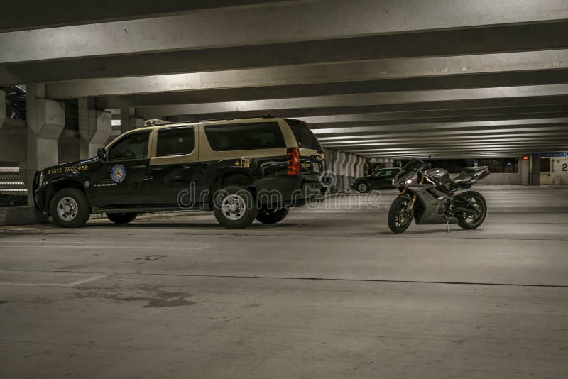 State trooper police car and a motorcycle in an underground parking lot - Beach motorcycle troopers