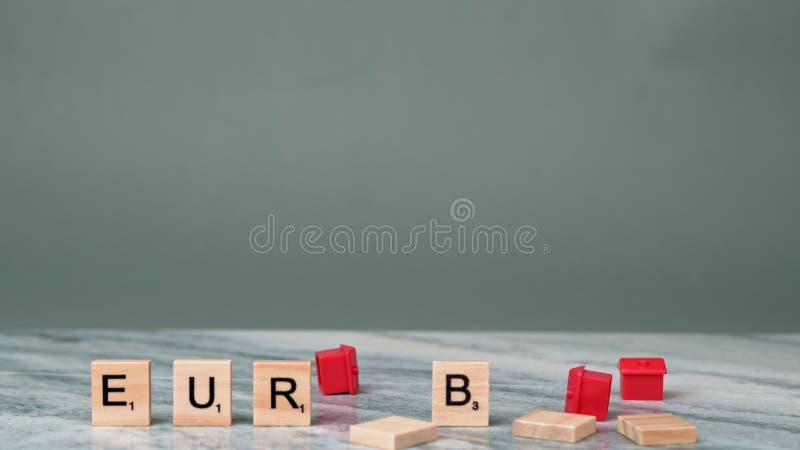 Static Shot of Word EURIBOR Is Written In Wooden Letters. Female Hand Throws Small Houses of Red Color on