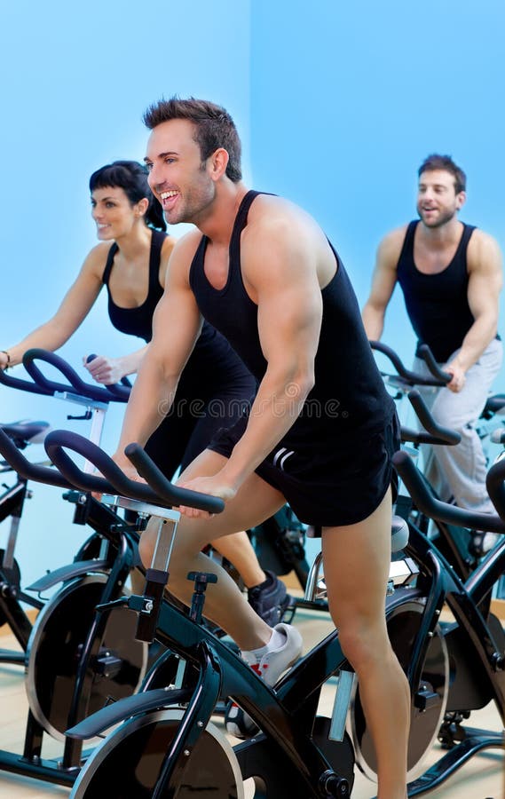 Stationary spinning bicycles fitness men in a gym sport club. Stationary spinning bicycles fitness men in a gym sport club