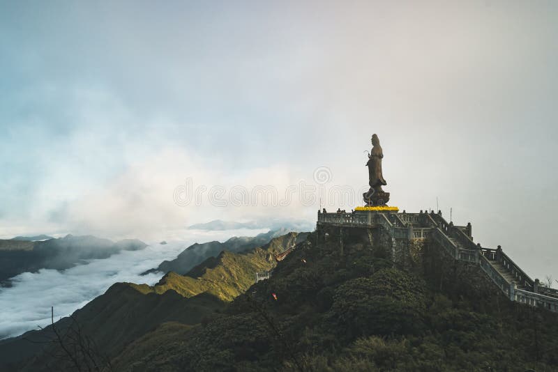 Statua Bodhisattva na Fansipan halnym szczycie wysoka góra w Indochina tła Pięknego widoku chmurze i niebieskim niebie fotografia stock Statua Bodhisattva na Fansipan halnym szczycie wysoka góra w Indochina tła Pięknego widoku chmurze i niebieskim niebie fotografia stock