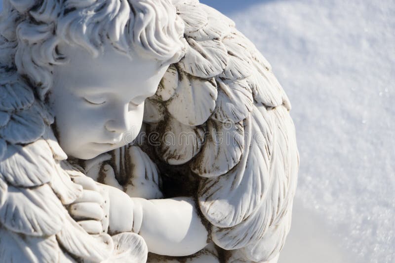 Statua dell'angelo addormentato Angel guardiano dormendo su fondo bianco di neve immagini stock libere da diritti Statua dell'angelo addormentato Angel guardiano dormendo su fondo bianco di neve immagini stock libere da diritti