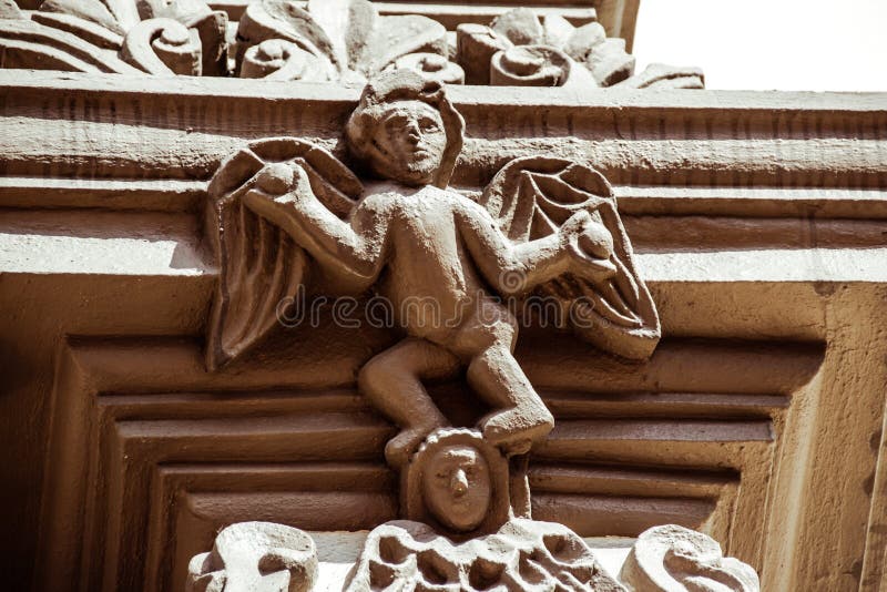 Statua di angelo nella vecchia facciata della chiesa fotografie stock Statua di angelo nella vecchia facciata della chiesa fotografie stock