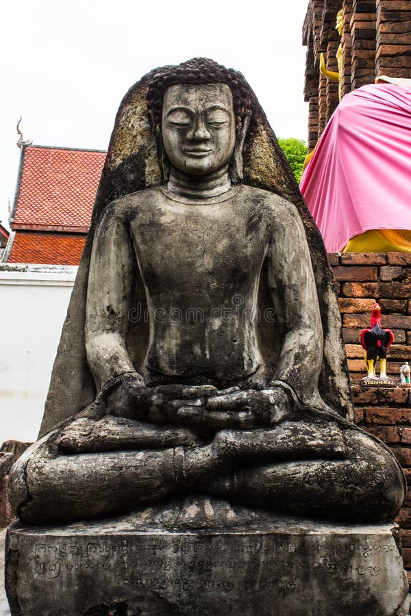 Statua di Buddha e vecchia pagoda, Wat Phra That Hariphunchai fotografia stock Statua di Buddha e vecchia pagoda, Wat Phra That Hariphunchai fotografia stock