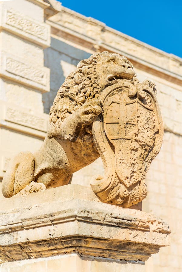 Statua di leone con il cavo d'arma vicino al cancello principale di vilhena a mdina immagine stock