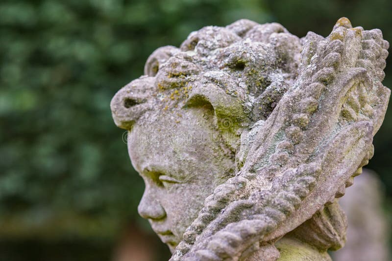 Statua di pietra di angelo in giardino Statua di angelo custode al sole come simbolo di amore in giardino immagine stock libera da diritti Statua di pietra di angelo in giardino Statua di angelo custode al sole come simbolo di amore in giardino immagine stock libera da diritti