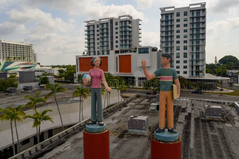 Statua di una coppia di uomini e donne in un distretto di design con edifici cittadini sullo sfondo immagine stock libera da diritti