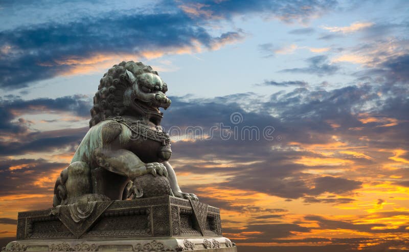 Statua maestosa del leone con la priorità bassa di incandescenza di tramonto immagine stock