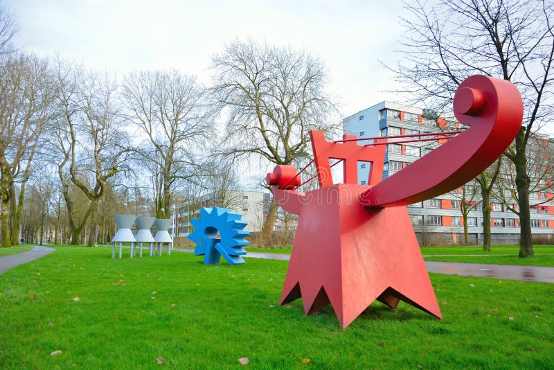 Statue contemporaine drôle en métal rouge et bleu en parc néerlandais image libre de droits Statue contemporaine drôle en métal rouge et bleu en parc néerlandais image libre de droits