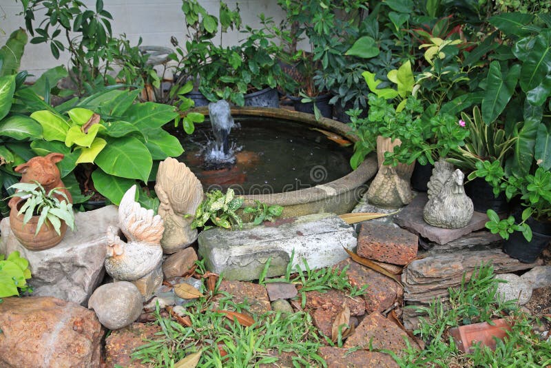 Statue del maiale e del pollo alla fontana delle terraglie in giardino fotografia stock Statue del maiale e del pollo alla fontana delle terraglie in giardino fotografia stock