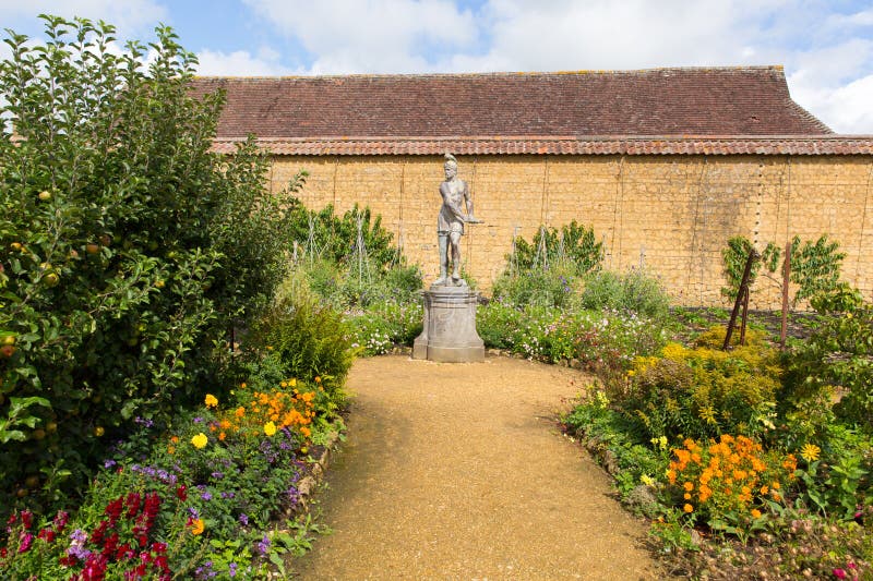 Statue in den Gärten Barrington Court nahe Ilminster Somerset England Großbritannien mit Gärten im Sommersonnenschein lizenzfreie stockfotos Statue in den Gärten Barrington Court nahe Ilminster Somerset England Großbritannien mit Gärten im Sommersonnenschein lizenzfreie stockfotos