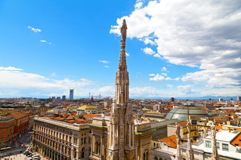 A statue of the Dome of Milan cathedral with the city view in summer.