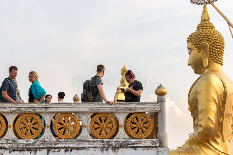 Statue of golden Buddha looks on tourists in the Wat Tham Suea Tiger cave temple royalty free stock photo Statue of golden Buddha looks on tourists in the Wat Tham Suea Tiger cave temple royalty free stock photo
